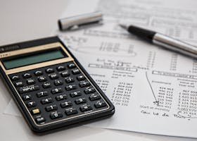 Close-up of financial documents with calculator and pen, ideal for business management themes.