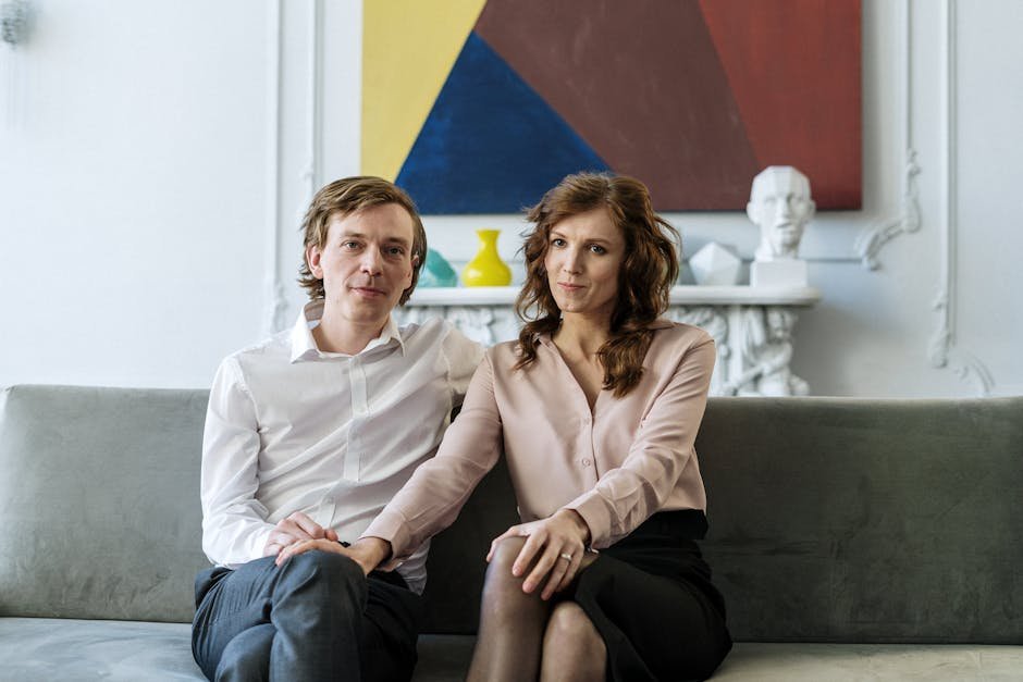 A couple sitting on a couch during a counseling session, showing connection and support.