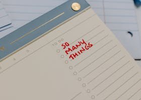 A planner with 'So Many Things' written, surrounded by loose notes.